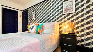 a bedroom with a bed and a black and white wall at Rest Boutique Golders Green in London