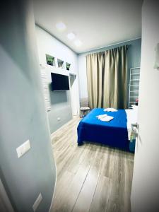 a bedroom with a blue bed and a television at Rodinó rooms in Naples
