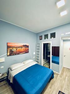 a blue bedroom with a bed and a painting on the wall at Rodinó rooms in Naples