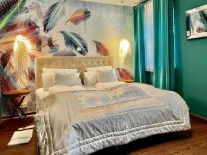 Schlafzimmer mit einem Bett mit Wandgemälde in der Unterkunft Boutique Hotel & Bio Wirtshaus Schwarzer Bock in Ansbach
