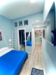 a blue bedroom with a bed and a mirror at Rodinó rooms in Naples