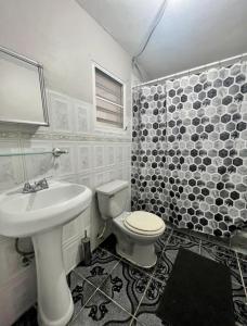 uma casa de banho branca com um lavatório e um WC em Country Paradise em Naguabo