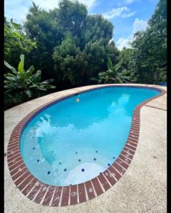 uma piscina com um caminho de tijolos à volta em Country Paradise em Naguabo