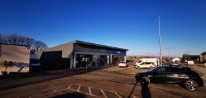 a car parked in a parking lot in front of a store at Newtown Apartments in Boʼness