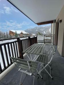 terraza con mesa y sillas en el balcón en Superbe appartement proche des pistes ! en Saint-Étienne-de-Tinée