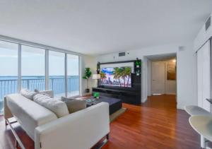 a living room with a white couch and a flat screen tv at Stunning 3 Bed Condo With Ocean View in Miami