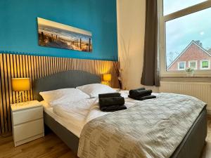 ein Schlafzimmer mit einem Bett mit zwei Kissen darauf in der Unterkunft Charmante Altbauwohnung an der Kesselschleuse 2 in Emden