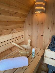 dentro de una sauna de madera con una toalla en Ferienhaus "Auszeit mit Herz" im Ferienpark Extertal - Kamin, Fass-Sauna, Massagesessel, en Extertal