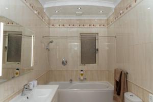 a bathroom with a tub and a sink and a toilet at Sea-View Studio Apartment - Sleeps 2 in Marsaskala