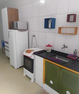 Elle comprend une petite cuisine équipée d'un réfrigérateur et d'un évier. dans l'établissement Apartamento em Guarujá a 200 m da Asturias e Tombo, à Guarujá