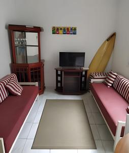 - un salon avec deux canapés et une télévision dans l'établissement Apartamento em Guarujá a 200 m da Asturias e Tombo, à Guarujá
