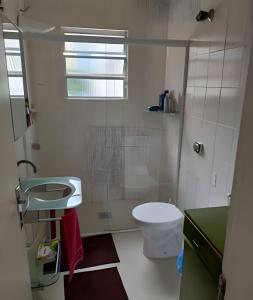 La salle de bains est pourvue d'une douche, de toilettes et d'un lavabo. dans l'établissement Apartamento em Guarujá a 200 m da Asturias e Tombo, à Guarujá