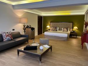 a large hotel room with a bed and a couch at Hôtel Des Gouverneurs in Bastia