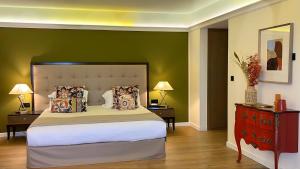 a bedroom with a large bed and a green wall at Hôtel Des Gouverneurs in Bastia
