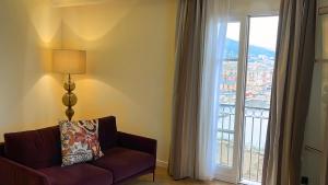 - un salon avec un canapé et une grande fenêtre dans l'établissement Hôtel Des Gouverneurs, à Bastia