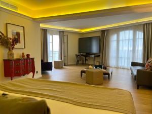 a hotel room with a bed and a flat screen tv at Hôtel Des Gouverneurs in Bastia