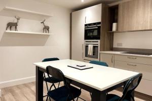 cocina con mesa y sillas en una habitación en LOVELY 3 BEDROOM APARTMENT WITH PRIVATE GARDEN IN EDINBURGH CITY CENTRE, en Edimburgo