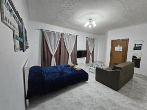 a bedroom with a bed and a couch and a chair at Sea-View Studio Apartment - Sleeps 2 in Marsaskala
