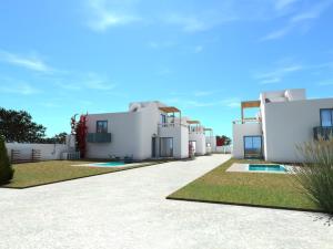 a row of white houses with a yard at Gemini Villas in Theologos