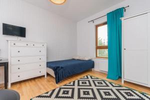a bedroom with a bed and a dresser and a window at Zajezdnia Wrzeszcz by Grand Apartments in Gdańsk
