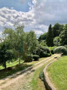 a dirt road in a park with trees and bushes at Bright, airy Annex in village with stunning views in Stroud