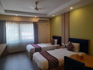 a hotel room with two beds and a table at Siddhartha Riverside Resort, Chumlingtar in Makaising