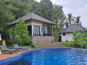 dom z basenem przed domem w obiekcie MAYURA BALI VILLA w mieście Munduk