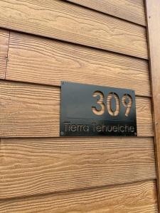 una señal en el lateral de una pared de madera en Tierra Tehuelche Hostería y Aparts en El Calafate