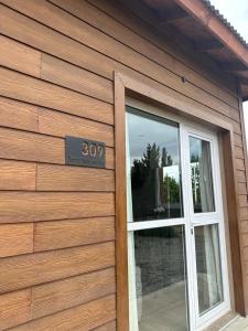 un edificio con una puerta con un cartel. en Tierra Tehuelche Hostería y Aparts en El Calafate