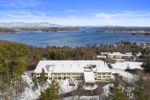 an aerial view of a building next to a body of water at Cute Lower Level Cedar Lodge Room with Balcony & Lake Views! in Laconia