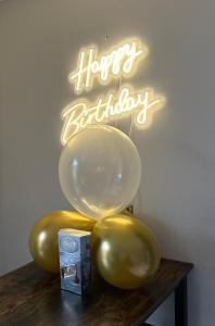 a group of balloons on a table with a happy birthday sign at Bothy Farm Stay Sleeps 2 HotTub and Pool Table Children Welcome Ayrshire Rural Retreats in Newmilns