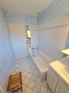 La salle de bains blanche est pourvue d'une baignoire et d'un lavabo. dans l'établissement Maison au calme . 5ième arr . Ouest Lyonnais, à Lyon