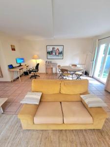 uma sala de estar com um sofá, mesas e cadeiras em Maison au calme . 5ième arr . Ouest Lyonnais em Lyon