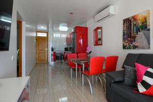 プラヤ・デル・イングレスにあるSol y Playaのリビングルーム(テーブル、赤い椅子付)