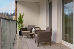 patio z krzesłami i stołem na balkonie w obiekcie Coast Apartment with Large, Furnished Balcony in Gąski by Renters w Gąskach