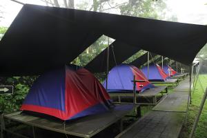 una fila de tiendas sobre una mesa bajo la lluvia en X CampGround, en Bukittinggi