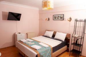 um quarto com uma cama e uma televisão na parede em Yeşim Suit Otel em Istambul