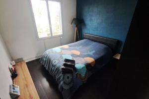 Schlafzimmer mit einem Bett mit blauen Wänden und einem Fenster in der Unterkunft Location de charme in Le Haillan