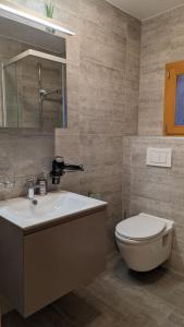 W łazience znajduje się umywalka, toaleta i lustro. w obiekcie Alpenblick Leukerbad w mieście Leukerbad