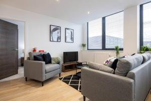 sala de estar con 2 sofás y TV en Pass the Keys Modern apartment - with parking, en Mánchester