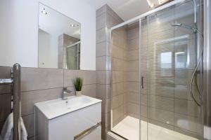 y baño con ducha acristalada y lavamanos. en Pass the Keys Modern apartment - with parking en Mánchester