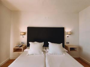 a bedroom with a large white bed with two pillows at FAY Victoria Beach in Rincón de la Victoria