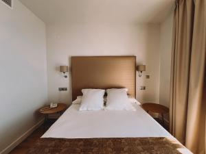 a bedroom with a large white bed with two pillows at FAY Victoria Beach in Rincón de la Victoria