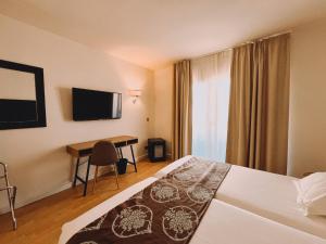 una camera d'albergo con letto e scrivania di Fay Victoria Beach a Rincón de la Victoria