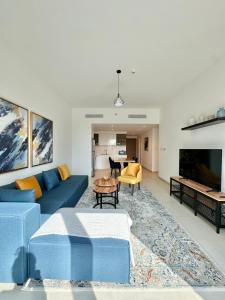 sala de estar con sofá azul y mesa en Luxury Apartment Downtown Dubai Mall Burj Khalifa View free Netflix & Prime Video, en Dubái