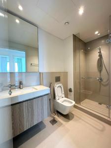 a bathroom with a toilet and a sink and a shower at Luxury Apartment Downtown Dubai Mall Burj Khalifa View free Netflix & Prime Video in Dubai