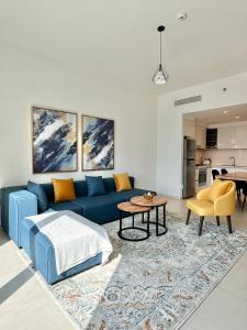 een woonkamer met een blauwe bank en een tafel bij Luxury Apartment Downtown Dubai Mall Burj Khalifa View free Netflix & Prime Video in Dubai