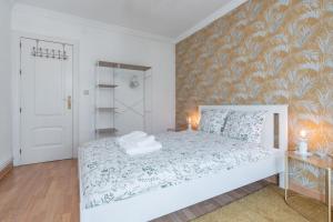 a bedroom with a white bed and a wall at tuGuest San Agustin II Apartment in Granada