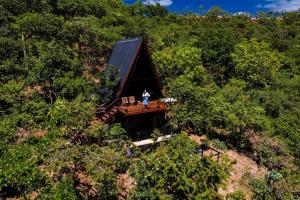 an overhead view of a person standing on a house in the woods at Cabana Arizona no The Country Huts in Novo Gama