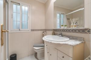 a bathroom with a sink and a toilet and a mirror at tuGuest San Agustin II Apartment in Granada